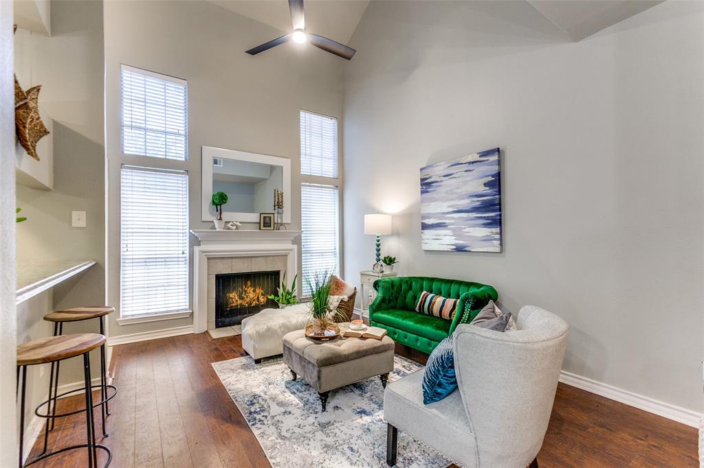 Vaulted ceilings, wood-finish flooring, fireplace with a mantel, and oversized windows
