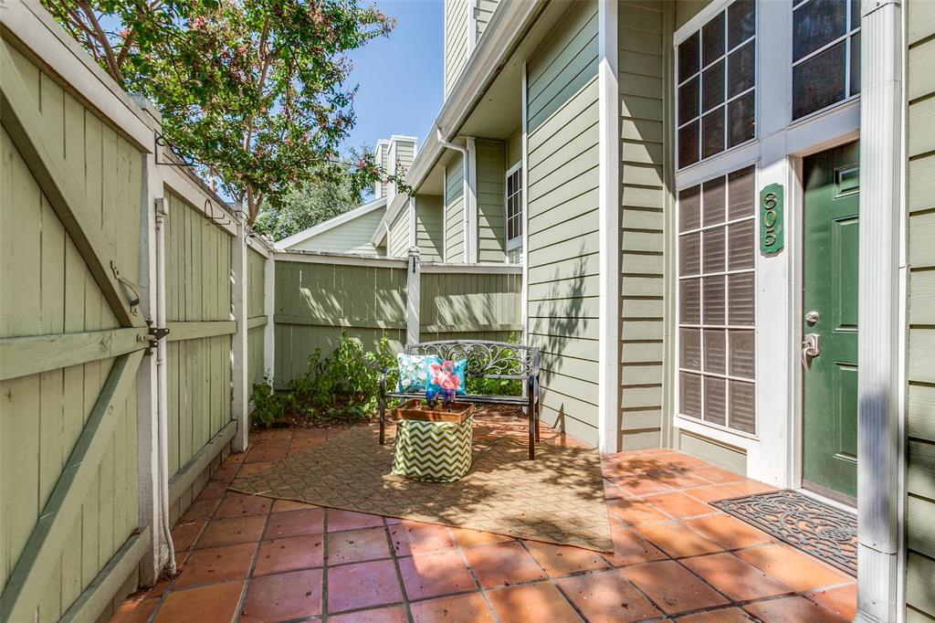 Private courtyard entrance featuring terracotta tile flooring, horizontal lap siding, a secure gate, and a multi-pane glass entry door with transom window