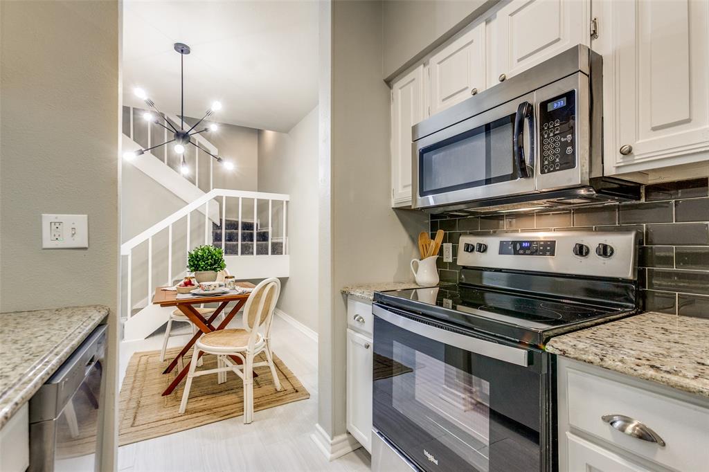 Kitchen featuring white cabinetry, stone-finish countertops, subway tile backsplash, and stainless steel appliances