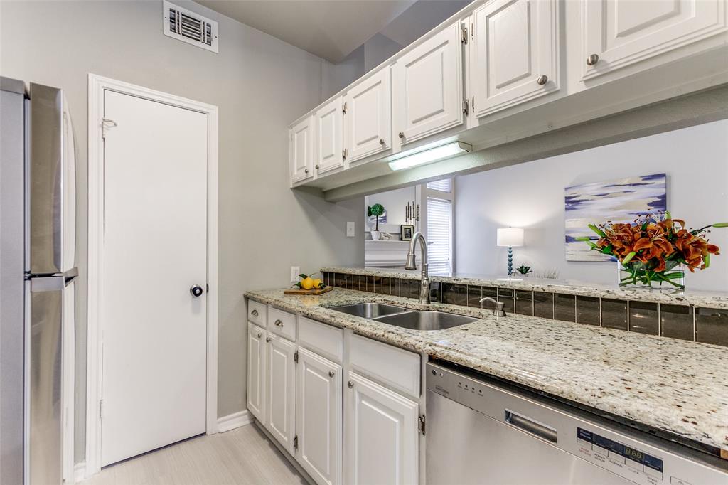 Kitchen featuring white cabinetry, light-toned stone-finish countertops, stainless steel undermount sink with arched pull-down faucet, and built-in stainless steel dishwasher