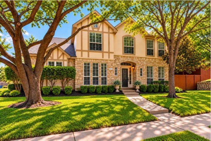 Large Corner Lot around the corner of Lake Ray Hubbard! Two-story exterior featuring stone veneer, , and a manicured landscape with mature trees