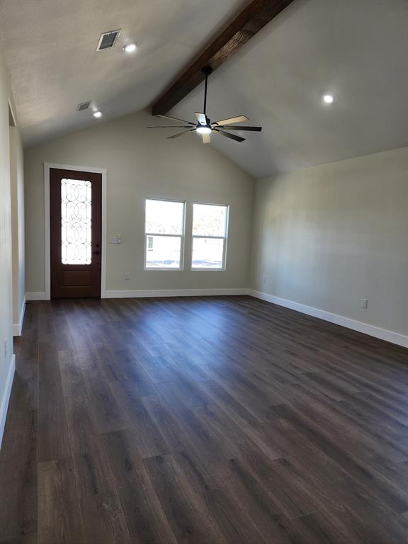 Vaulted ceiling featuring a decorative wood-finish beam, wood-finish flooring, recessed lighting, a modern ceiling fan, and an entry door with an ornamental glass insert Vaulted ceiling featuring a decorative wood-finish beam, wood-finish flooring, recessed lighting, a modern ceiling fan, and an entry door with an ornamental glass insert
