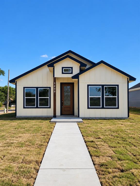Board-and-batten exterior with contrasting trim, gable roof lines, decorative glass-panel front door, and concrete walkway Board-and-batten exterior with contrasting trim, gable roof lines, decorative glass-panel front door, and concrete walkway