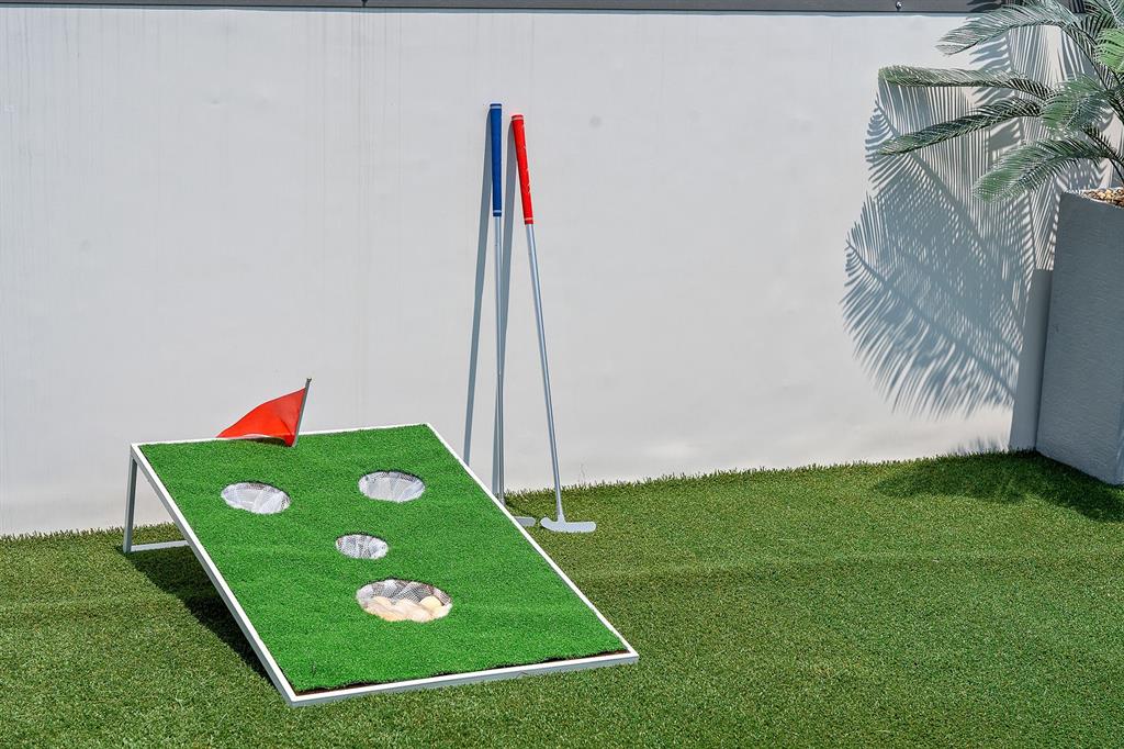 Outdoor space featuring synthetic turf surfacing and a solid wall boundary