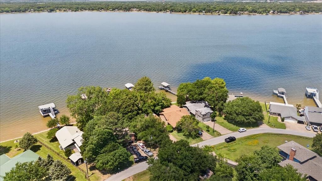 Aerial perspective featuring direct water frontage, private boat dock, shoreline access, and mature tree canopy