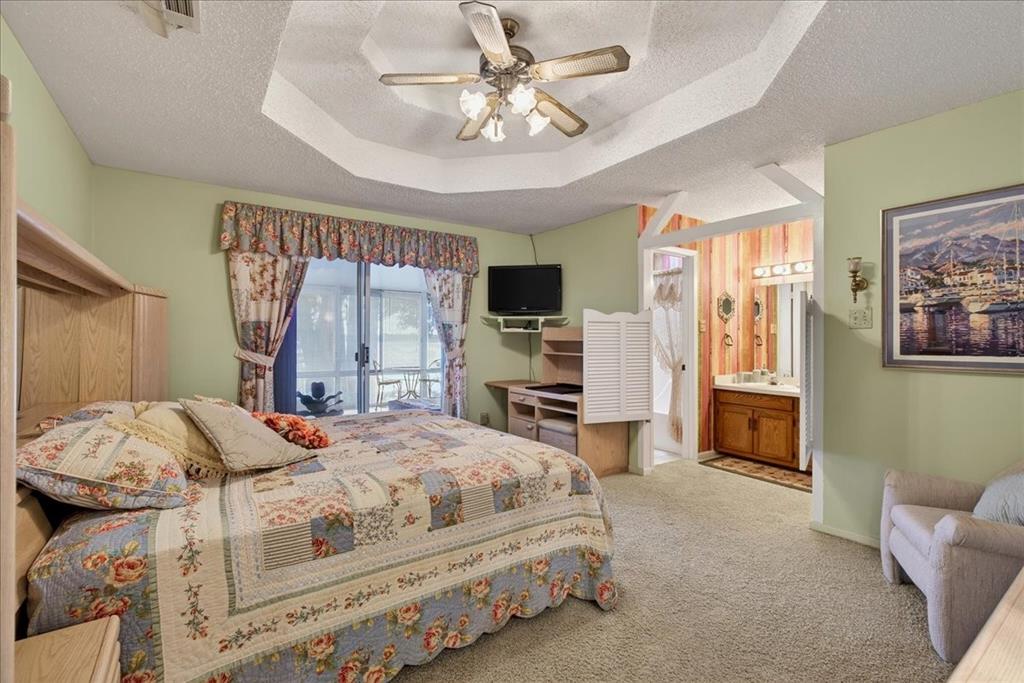 Octagonal tray ceiling with a central multi-light fan, sliding glass door, and built-in wood cabinetry