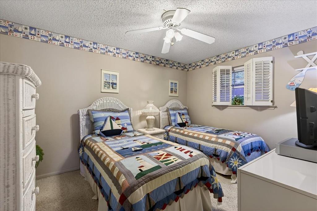 Carpeted flooring, ceiling fan with integrated lighting, and operable shutter window treatments