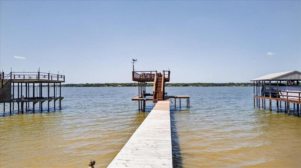 Waterfront pier featuring a multi-level wood deck, metal railing, and an integrated staircase