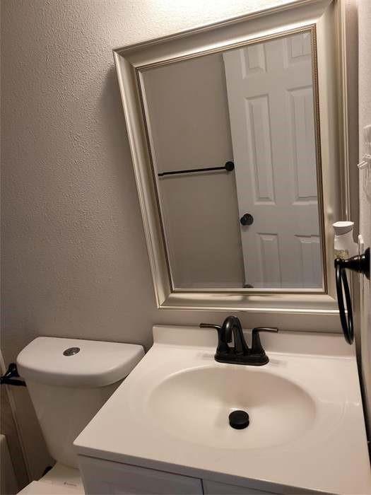 Vanity featuring an integrated sink, matte black faucet, framed wall mirror, and matte black hardware