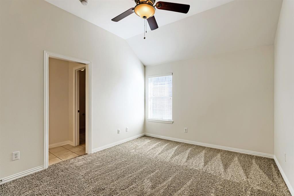 Vaulted ceiling featuring a ceiling fan with integrated lighting, wall-to-wall carpeting, and a single-window configuration