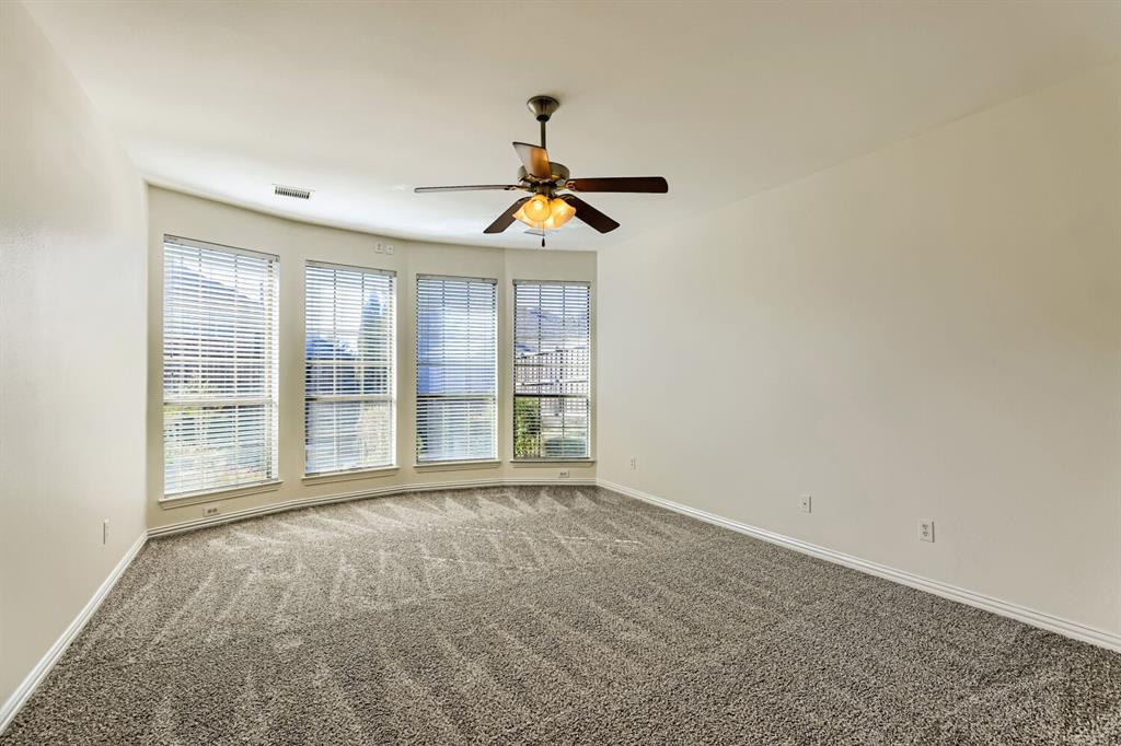 Wall-to-wall carpeting, four large windows, and a ceiling fan with integrated lighting