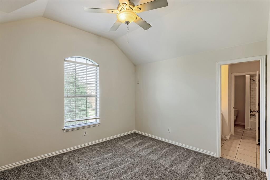 Vaulted ceilings, carpeted flooring, arched window, and overhead ceiling fan with integrated lighting
