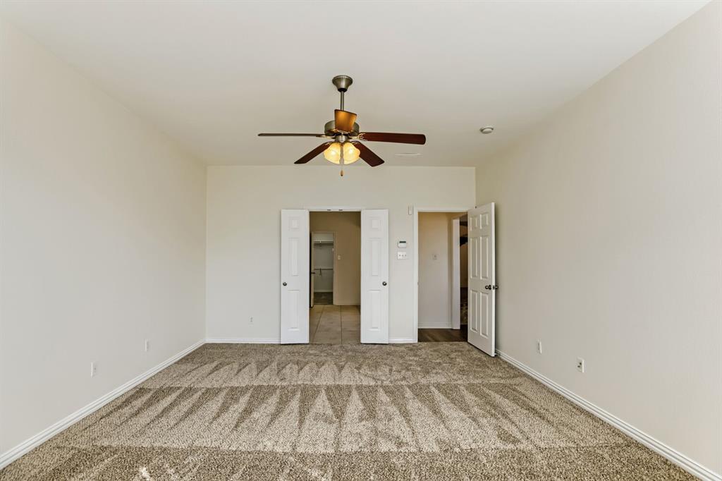 Room featuring wall-to-wall carpeting, a ceiling fan with integrated lighting, and multiple interior paneled doors