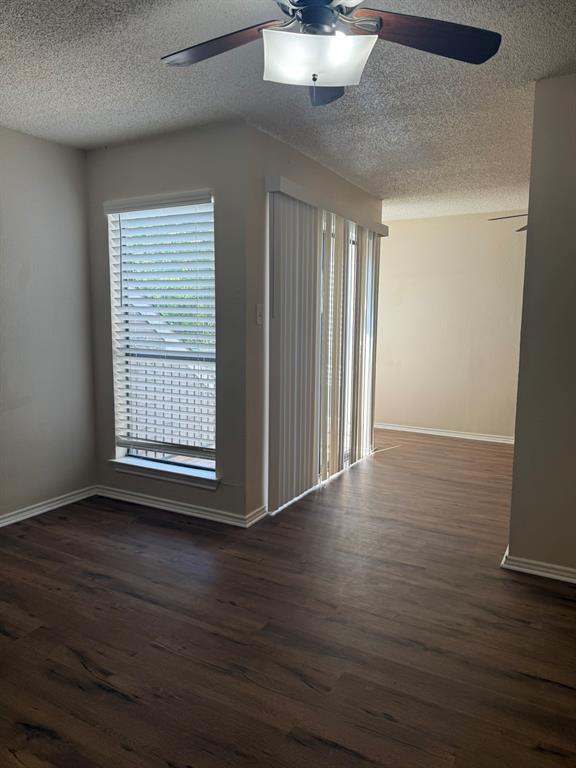 Wood-finish flooring, ceiling fan with integrated lighting, vertical blinds, and a large window with horizontal blinds