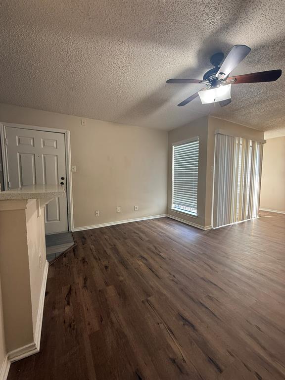 Wood-finish flooring, ceiling fan with integrated light fixture, and vertical blinds