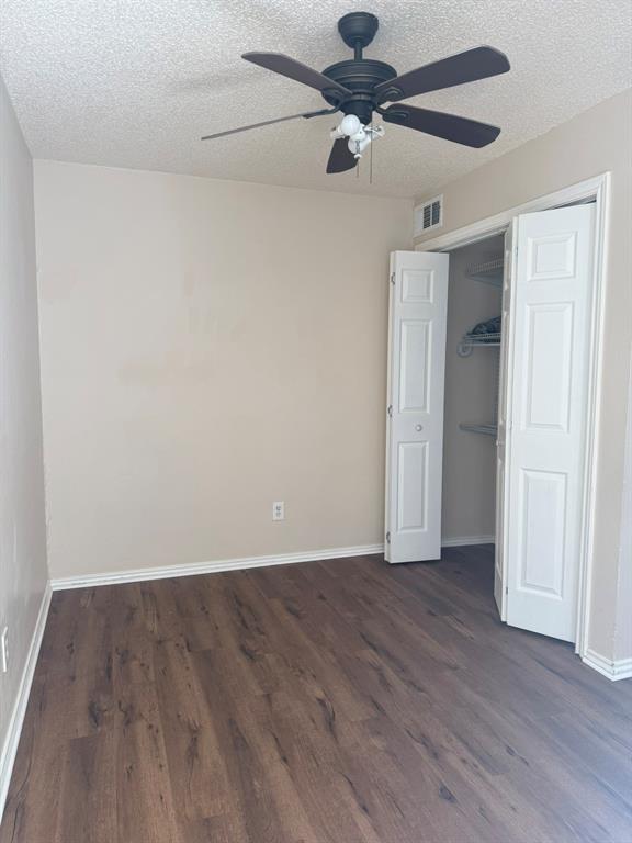Wood-finish flooring, ceiling fan with integrated lighting, and closet with bifold doors and built-in shelving
