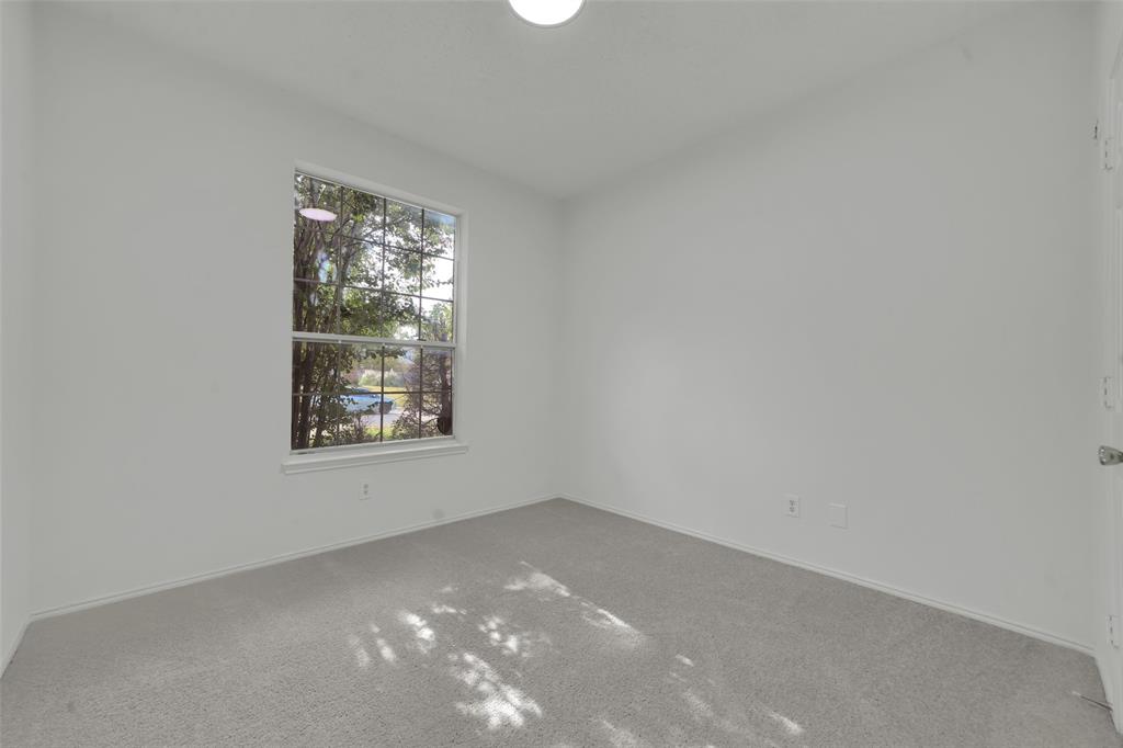 Neutral interior featuring wall-to-wall carpeting, a single-hung window, and a ceiling-mounted light fixture