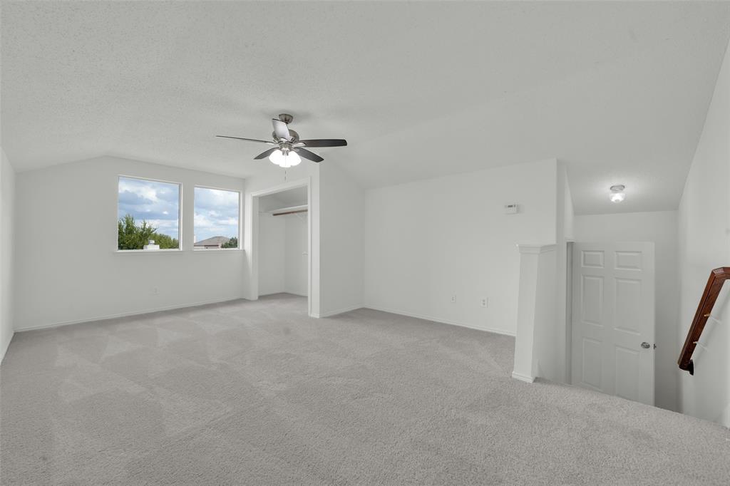 Vaulted ceilings, carpeted flooring, ceiling fan with light fixture, and natural light from dual windows