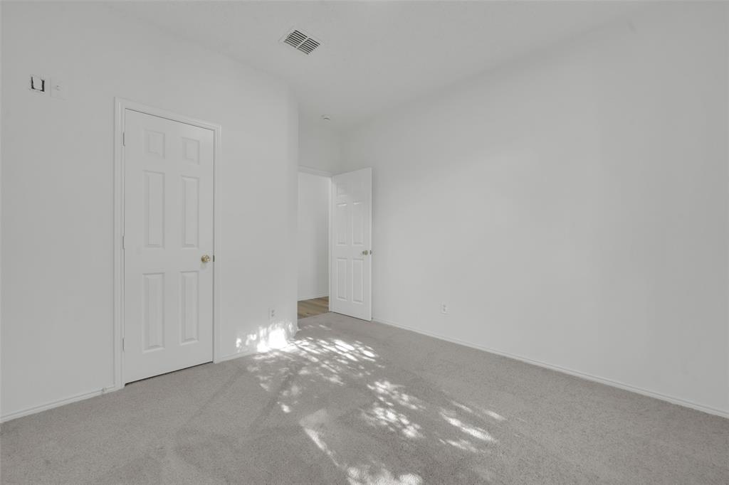 Neutral-toned interior space featuring wall-to-wall carpeting, white walls, and two six-panel interior doors