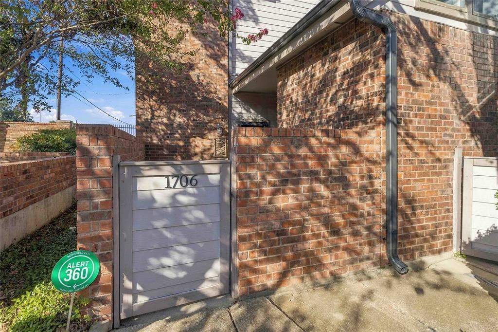 Exterior facade featuring a brick masonry finish, a private gated entrance, and horizontal paneling detail