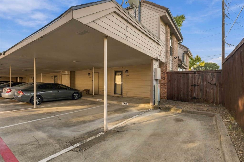 Exterior view featuring a two assigned covered carport parking spots plus additional guest spot and a wood privacy fence