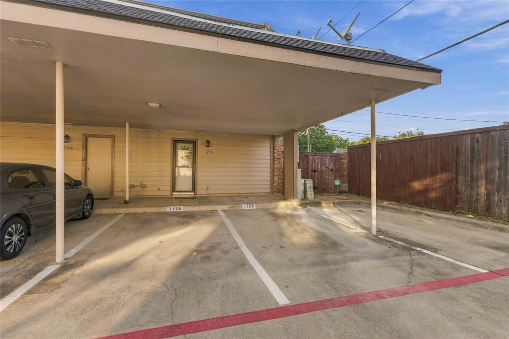 Exterior view featuring a two assigned covered carport parking spots plus additional guest spot and a wood privacy fence