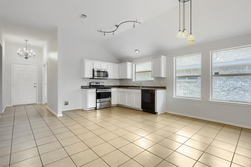 Room featuring vaulted ceilings, wood-finish flooring, and a ceiling fan with integrated lighting