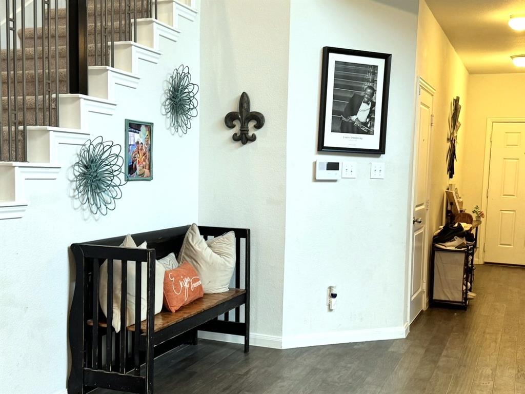 Entryway featuring wood-finish flooring, a staircase with metal balusters, and recessed ceiling lighting