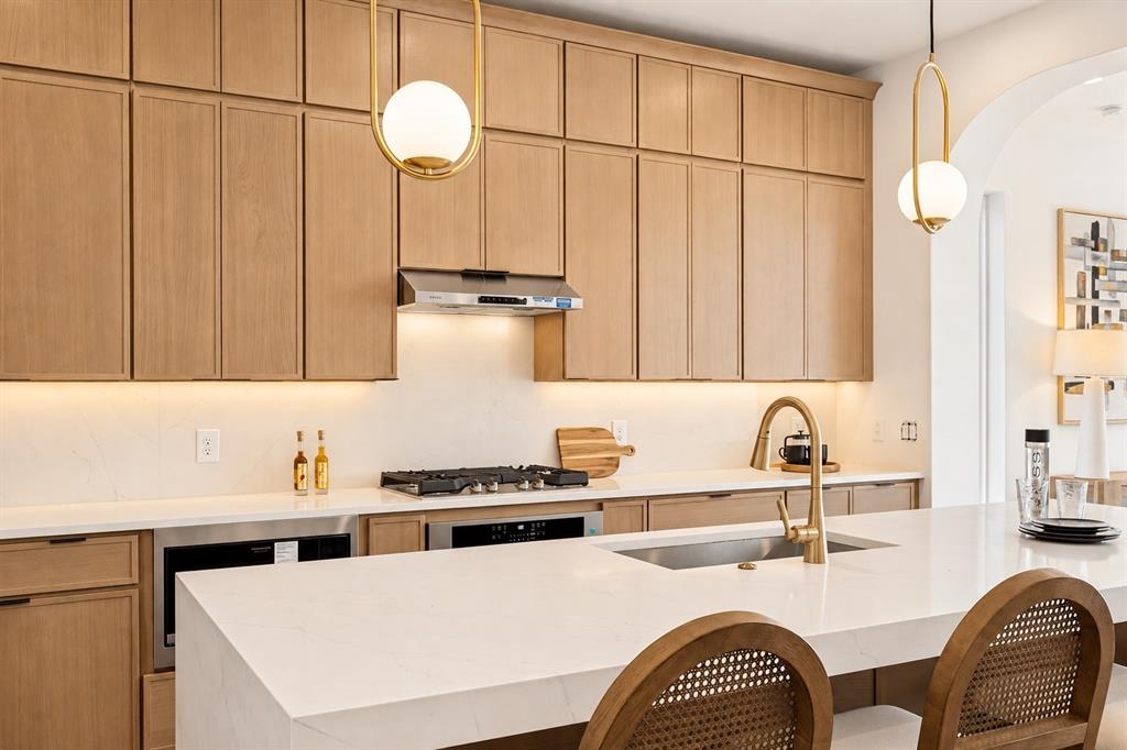 Wood-finish cabinetry with full overlay doors, integrated stainless steel appliances, and a gas cooktop