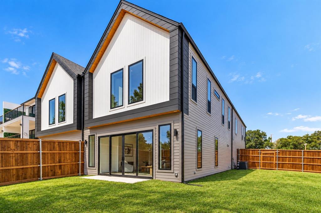 Contemporary architecture featuring a peaked roofline, vertical white siding, gray horizontal siding, and multiple large windows