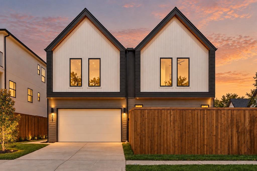 Contemporary architectural style featuring white board and batten siding, dark trim, and a prominent peaked roofline