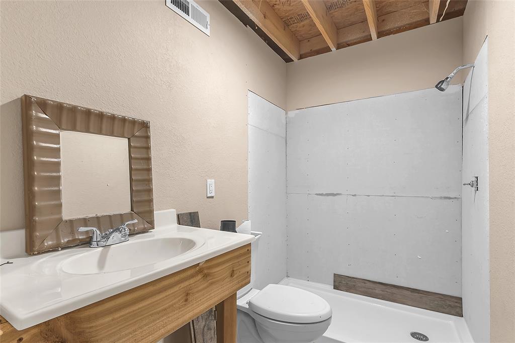 Bathroom in progress with vanity, toilet, and walk-in shower base
