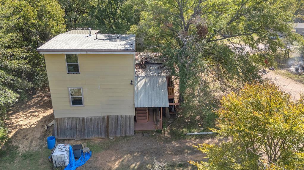 Aerial of two-story home with metal roof and covered rear deck