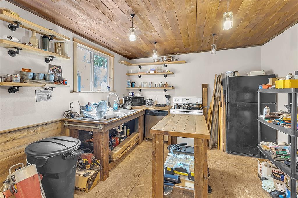 Kitchen with open wood shelving, wood island, and pendant lights