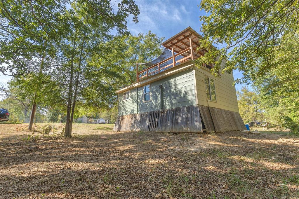 Exterior with upper covered deck and mature shade trees