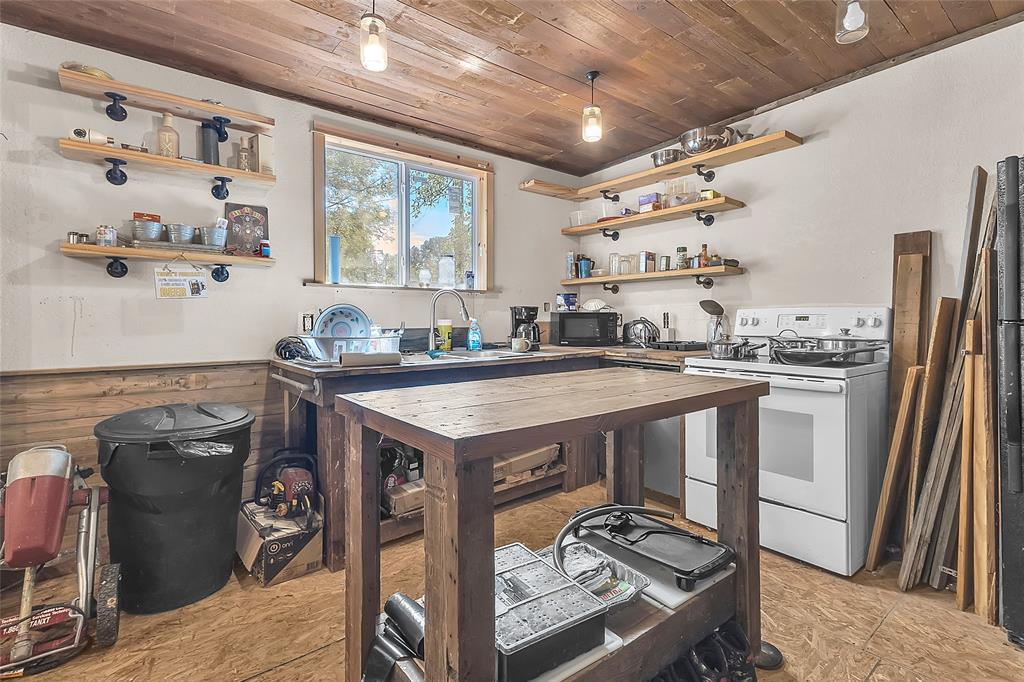 Kitchen with white range, open shelving, and wood island