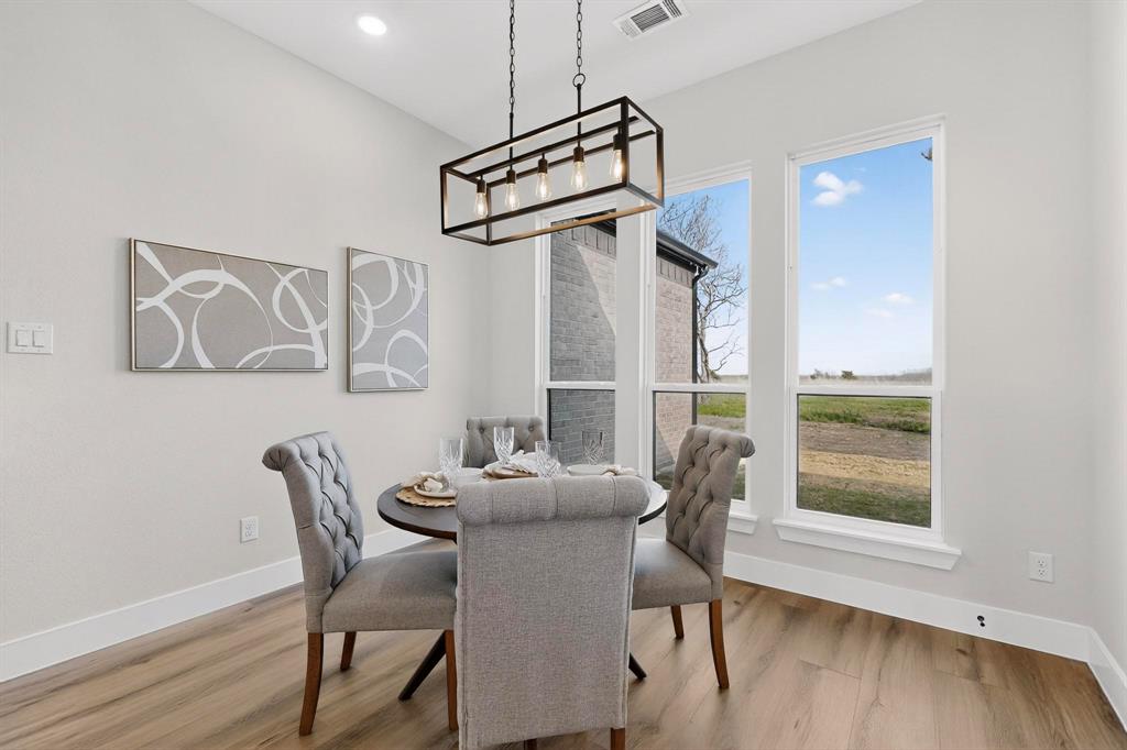 Neutral color palette featuring wood-finish flooring, recessed lighting, and a modern rectangular metal pendant light fixture