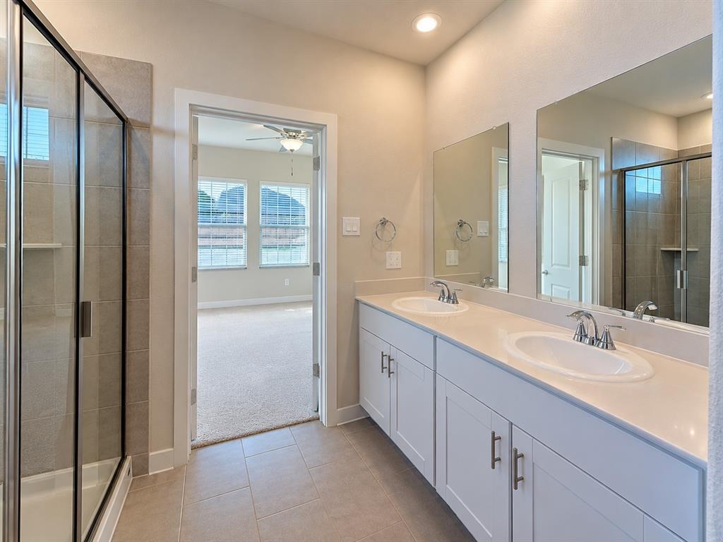 Double vanity with white cabinetry, solid-surface countertop, and dual oval undermount sinks