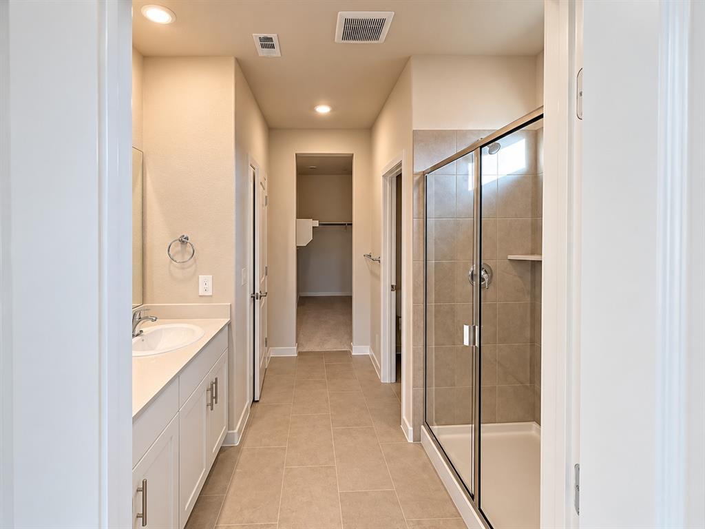 Double vanity with white cabinetry, solid-surface countertop, and dual oval undermount sinks