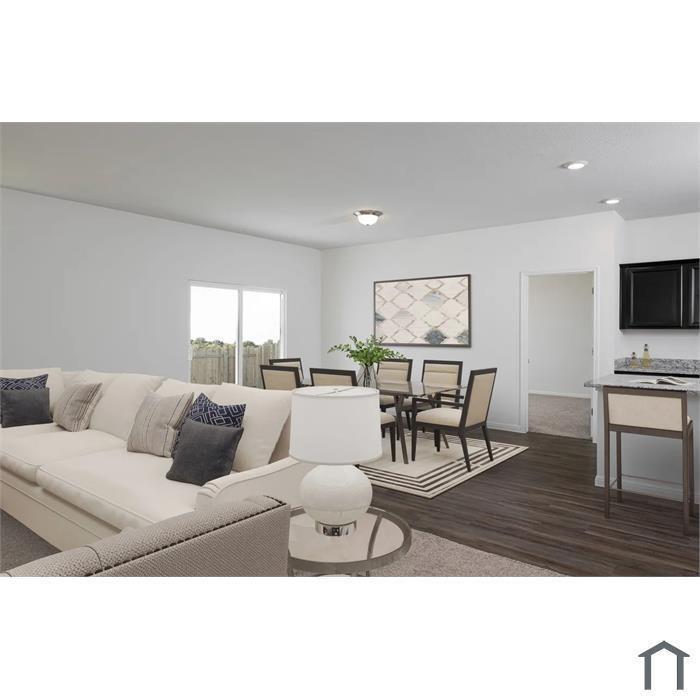 Open-concept interior featuring wood-finish flooring, recessed lighting, and a kitchen breakfast bar with stone-surface countertop