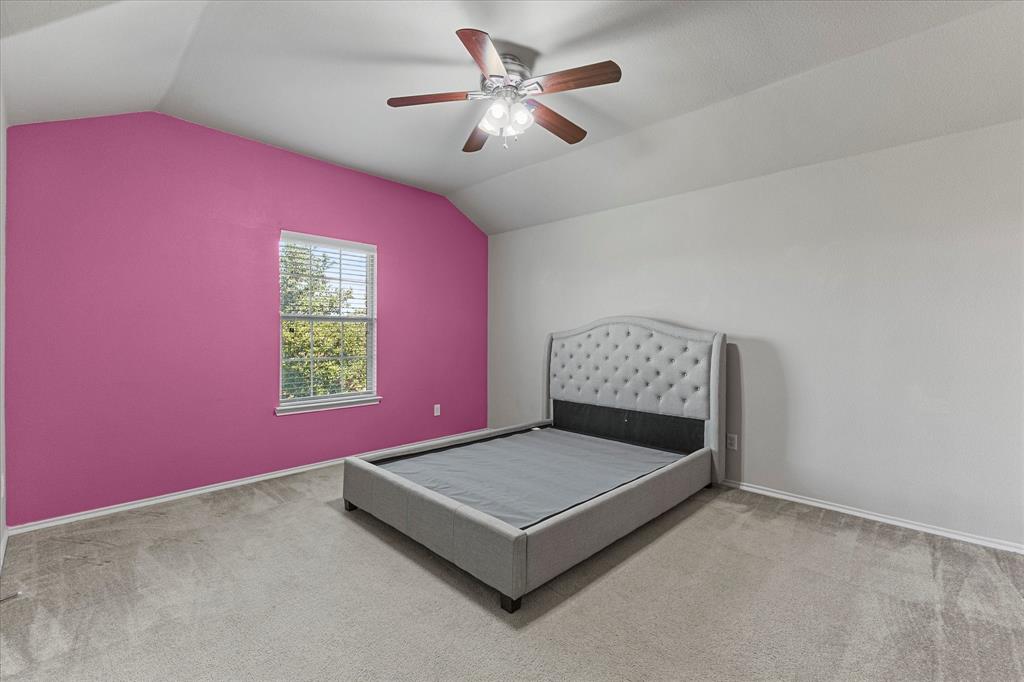 Vaulted ceilings, carpeted flooring, and a central ceiling fan with integrated lighting