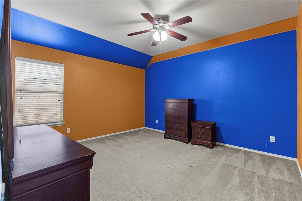 Vaulted ceiling with integrated ceiling fan, neutral carpeting, and horizontal slat window blinds