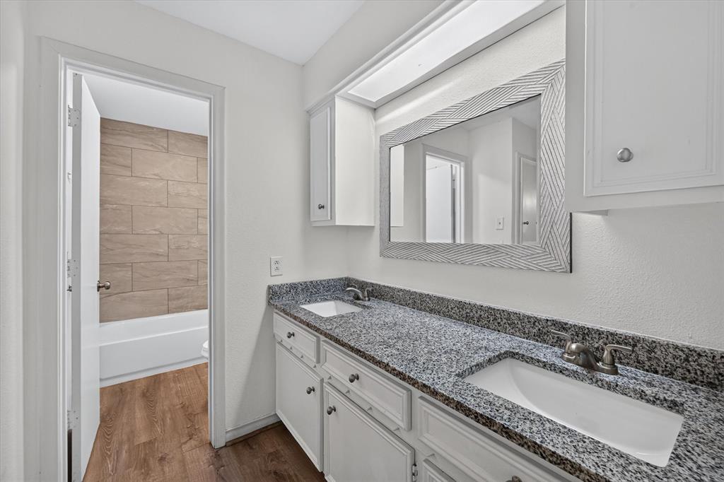 Dual-vanity cabinet with stone-finish countertop, undermount sinks, and integrated lighting