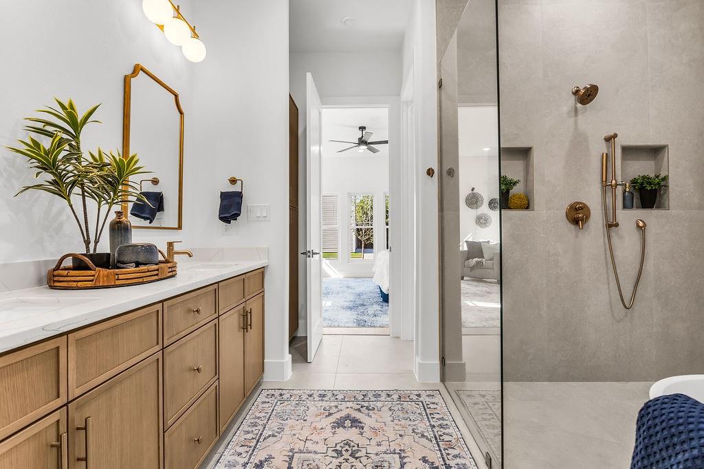 Spa-caliber primary bath with freestanding soaking tub, frameless walk-in shower, fluted tile accent wall, and Delta Trinsic brushed gold fixtures