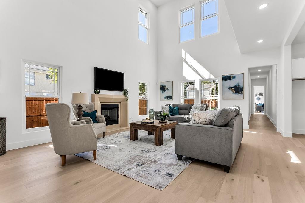 Soaring 2-story great room with gas fireplace, clerestory windows, and wide-plank white oak engineered hardwood