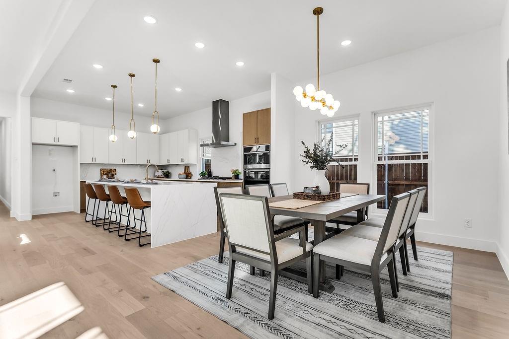 Open-concept dining seamlessly connects the kitchen, great room, and covered rear patio