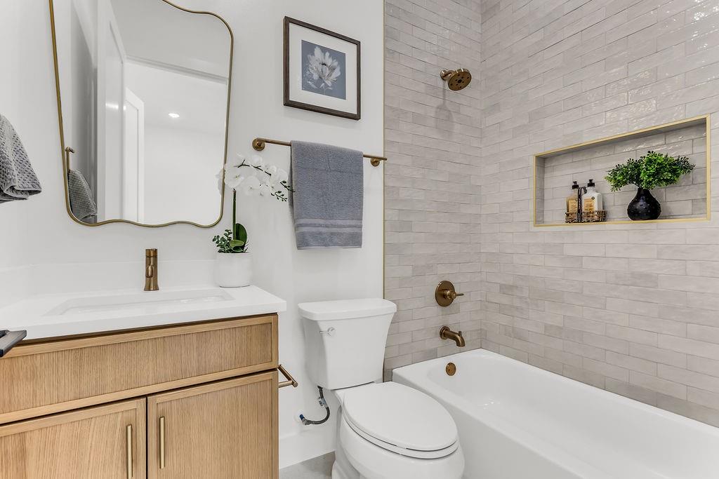 Designer full bath with quality tile work and modern fixtures — mirrors the elevated finishes found throughout the home