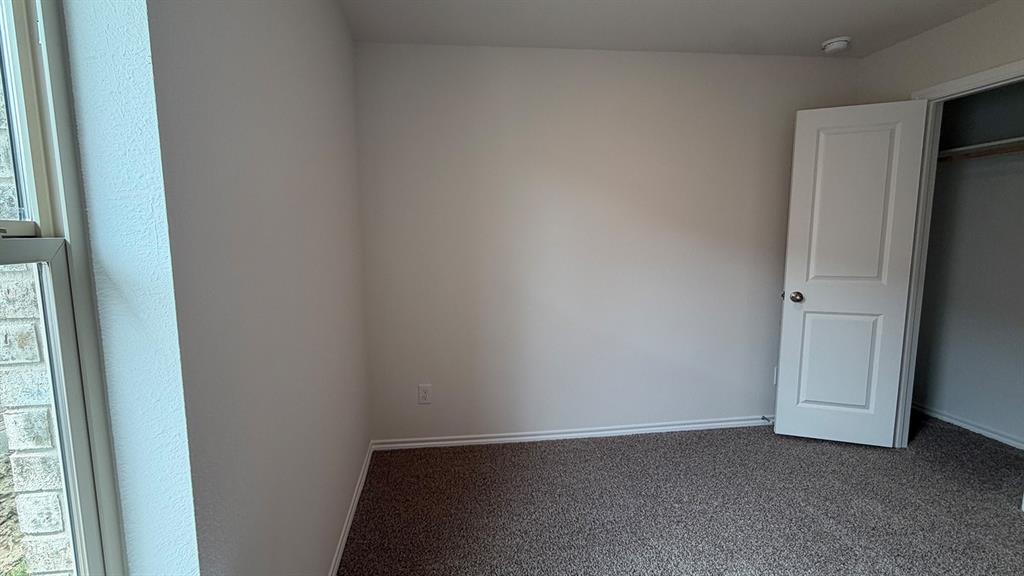Recessed lighting illuminates neutral carpeting and light-colored walls