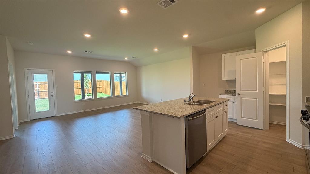 Open-concept living area featuring wood-finish flooring, recessed lighting, and multiple windows