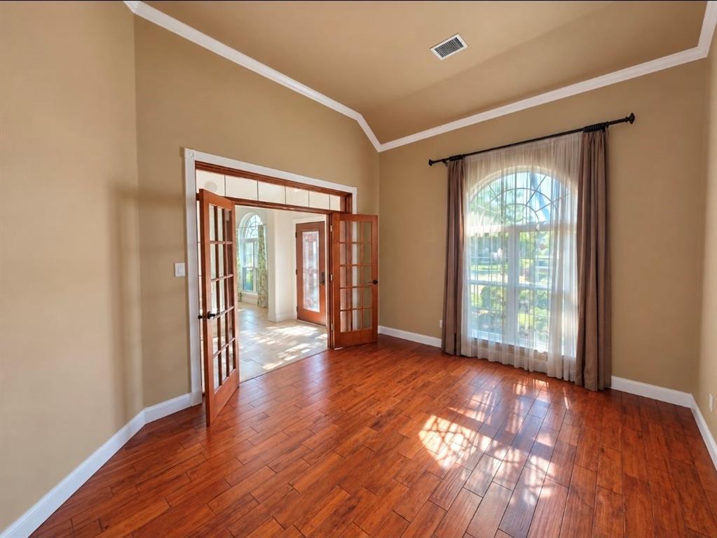 Vaulted ceilings, wood-finish flooring, and arched window with decorative muntins Vaulted ceilings, wood-finish flooring, and arched window with decorative muntins